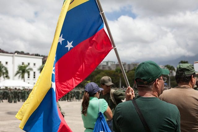A citizen holds a Venezuelan national flag during the military exercises convened by Venezuelan President Nicolas Maduro, in Caracas, Venezuela, on March 14, 2015. Venezuelan Defense Minister Vladimir Padrino Lopez inaugurated the ten-day military exercises on Saturday, which he said was launched due to the urgent need to defend the integrity of the nation. (Xinhua/Boris Vergara) (jg)
