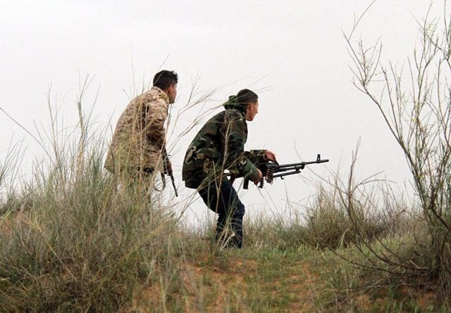Two Libya Dawn fighters identify positions of their rivals near Bir al-Ghanam, Libya, on March 21, 2015. Clashes continued between Libya Dawn fighters and pro-government forces on Saturday near Bir al-Ghanam, some 90 kilometers southwest of the capital Tripoli. (Xinhua/Hamza Turkia)