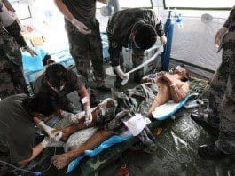 A rescued man receives medical treatment at a hospital of the People's Liberation Army in Tianjin, north China, Aug. 15, 2015. The man in his fifties was rescued from the Tianjin blasts site on Saturday afternoon. Specialized anti-chemical soldiers found him 50 meters away from a burst point. The man was conscious and could talk. He was rushed to a hospital in the city. A total of 70 specialized anti-chemical soldiers entered the core area of the blasts site on Saturday morning to search for possible lives. (Xinhua/Wang Haobo) (lfj)