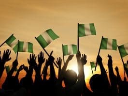 Group of People Waving Flag of Nigeria in Back Lit