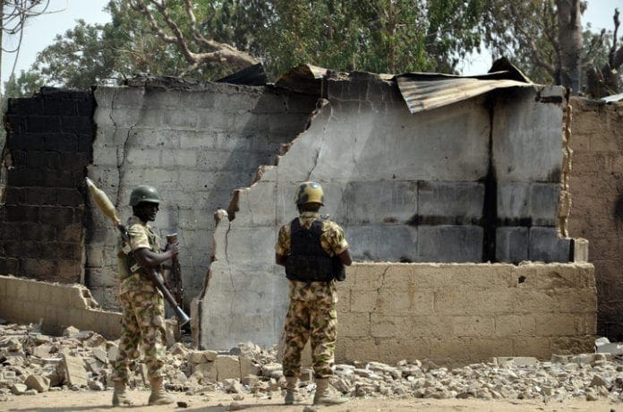 NIGERIA-UNREST-ISLAMISTS Soldiers looks at burnt house on February 4, 2016 during a visit to the village of Dalori village, some 12 kilometres from Borno state capital Maiduguri, northeastern Nigeria, after an attack by Boko Haram insurgents on the village left at least 85 people dead on January 30, 2016. At least 85 people died when Boko Haram insurgents stormed and torched a village on January 30 near the restive northeast Nigerian city of Maiduguri, a state commissioner said on February 1, 2016. Boko Haram, which seeks a hardline Islamic state in northern Nigeria, has killed some 17,000 people and forced more than 2.6 million others to flee their homes since 2009. / AFP / STRINGER (Photo credit should read STRINGER/AFP/Getty Images)