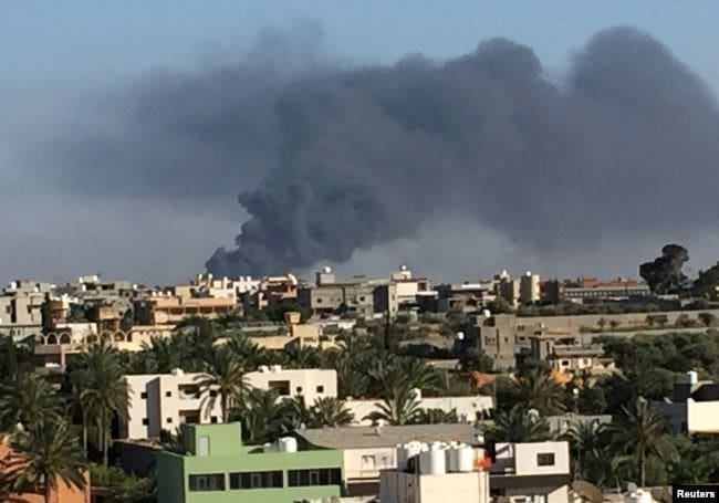 FILE - Smoke rises during a fight between members of the Libyan internationally recognized government forces and Eastern forces in Ain Zara, Tripoli, Libya, May 5, 2019. FILE - Smoke rises during a fight between members of the Libyan internationally recognized government forces and Eastern forces in Ain Zara, Tripoli, Libya, May 5, 2019.