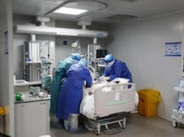 Medics rescue a COVID-19 patient at Huoshenshan Hospital, Wuhan, Feb. 24, 2020. Photo by Wang Haoyu/People’s Daily Online