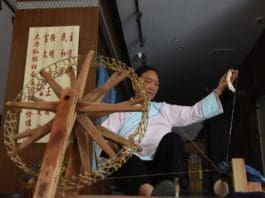 Photo shows a senior woman of the Buyi ethnic group makes yarn with a spinning wheel. Photo by Zhang Chunlei