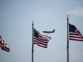 A plane flies in the sky with the U.S. national flags in the foreground in Washington, D.C., the United States, on July 21, 2020. U.S. President Donald Trump said Tuesday afternoon that the coronavirus pandemic in the United States will probably "get worse before it gets better." More than 3.8 million people in the United States have infected with the virus, with more than 141,000 deaths, according to a count by Johns Hopkins University, as some states, including Florida, are seeing a surge in cases. (Xinhua/Liu Jie)