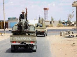 A fighter of the UN-recognized Libyan government gestures on a pickup truck in the Abu Qurain area about 300 kilometers east of the Libyan capital Tripoli, July 20, 2020.