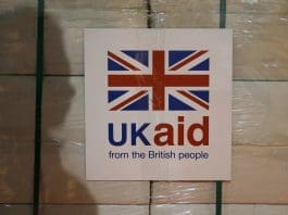 A UK Aid label is attached to a box containing kitchen sets