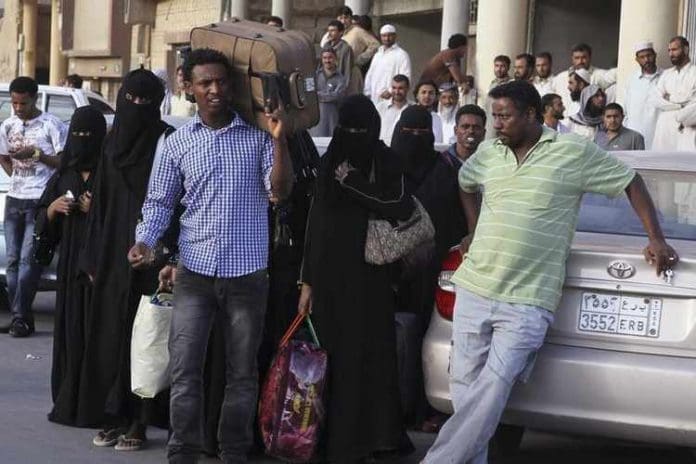 FILE PHOTO: An Ethiopian worker carries his suitcase, as he waits along with his countrymen to be repatriated, in Manfouha, southern Riyadh, Saudi Arabia on November 10, 2013. REUTERS/Faisal Al Nasser