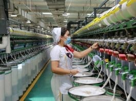 A woman works at a workshop of a textile factory in Awat county, Aksu, northwest China's Xinjiang Uygur autonomous region, July 10, 2021. The factory is preparing a 1,200-tonne order for its clients in Shandong, Jiangsu and Zhejiang provinces. (Photo by Bao Liangting/People's Daily Online)