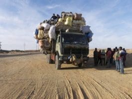 An Elderly Man Climbs Onto A Lorry Carrying Migrants And Goods Beside The Southern Libya Highway Towards Niger Near The Outskirts Of Sebha Scaled X