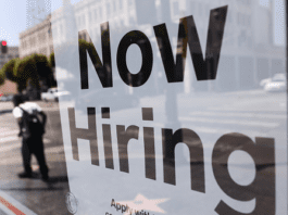 FILE PHOTO: A 'Now Hiring' sign is posted at a 7-Eleven store in Los Angeles, California. /Getty Images