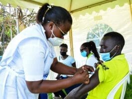 A health worker administers a dose of Sinovac COVID-19 vaccine for a man in Kampala, capital of Uganda, Sept. 23, 2021. Uganda Breweries has joined other local partners to fast track the country's COVID-19 vaccination in efforts to open up the country's economy. The company together with Century Bottling, a soda company, Private Sector Foundation Uganda and Kampala Capital City Authority on Wednesday launched the vaccination campaign dubbed "COVID-19: The fight is on! Get Vaccinated!" (Photo by Hajarah Nalwadda/Xinhua)