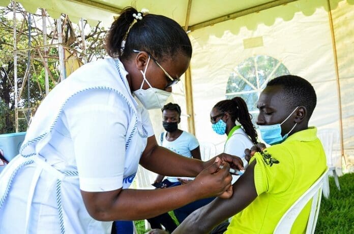 A health worker administers a dose of Sinovac COVID-19 vaccine for a man in Kampala, capital of Uganda, Sept. 23, 2021. Uganda Breweries has joined other local partners to fast track the country's COVID-19 vaccination in efforts to open up the country's economy. The company together with Century Bottling, a soda company, Private Sector Foundation Uganda and Kampala Capital City Authority on Wednesday launched the vaccination campaign dubbed "COVID-19: The fight is on! Get Vaccinated!" (Photo by Hajarah Nalwadda/Xinhua)