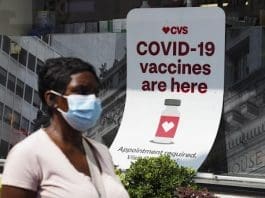 A man walks past a sign of COVID-19 vaccination at a pharmacy in New York, the United States, Aug. 11, 2021. (Xinhua/Wang Ying)