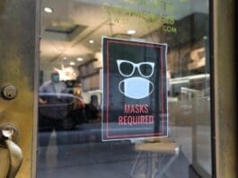 A sign is seen at the entrance to an optical shop in New York City, the United States, Aug. 2, 2021. (Xinhua/Wang Ying)
