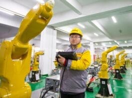 A worker tests industrial robots at a factory of a robot company at Hai’an economic and technological development zone, east China’s Jiangsu province, Jan. 5, 2022. (Photo by Zhai Huiyong/People’s Daily Online)