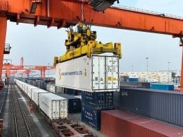 Containers are unloaded from a train carrying fresh fruits that arrived in Chengdu, capital of Sichuan province, via the China-Laos Railway, December 2022. It is the first delivery of imported fruits via the railway to the city. (Photo by Bai Guibin/People's Daily Online)
