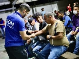 IOM staff helping migrants and refugees from Venezuela before boarding a relocation flight from Boa Vista in southern Brazil. Photo: IOM/Gema Cortes