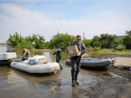 IOM partners bringing aid items to rural areas in Kherson by boat. Photo: Rescue Now 2023