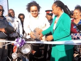 Eastern Province DPS Ms. Beauty Undi Phiri and the Fish for Food Security in Zambia Project Coordinator, Ms. Samanta Mapfumo, cutting a ribbon during the handover of eleven new motorbikes to the Ministry of Fisheries and Livestock.