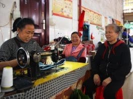 A tailor mends clothes for citizens in a market in Tongdao Dong autonomous county, central China's Hunan province, April 4, 2023. (Photo by Li Shangyin/People's Daily Online)
