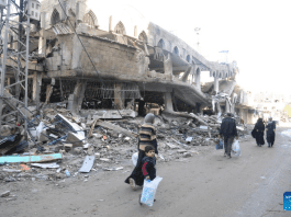 People Walk Past Destroyed Buildings At Jabalia Refugee Camp Northern Gaza Strip On Jan