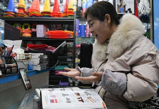 An employee of a foreign trade company in Yiwu, east China's Zhejiang province sells sports equipment to a Bolivian client via video links at the Yiwu International Trade Market. (Photo by Shi Kuanbing/People's Daily Online) An Employee Of A Foreign Trade Company