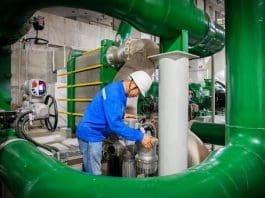 A staff member is adjusting the valves of the closed-loop cooling water system for the compressor at a compressed air energy storage station. (Photo by Ding Xiaowei)