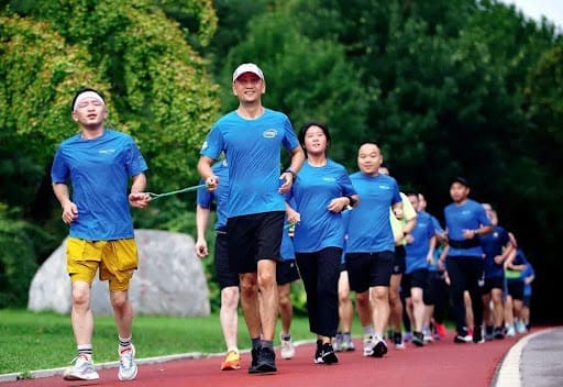 Individuals with visual impairment run at the Beijing Olympic Forest Park, guided by volunteers. (Photo by Zhang Ximeng) Individuals With Visual Impairment Run At The Beijing Olympic Forest Park