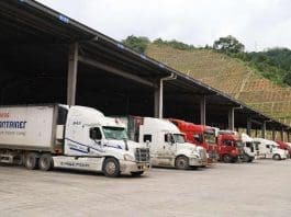 Fruits are about to be unloaded from trucks at a fruit trading center in Youyi township, Pingxiang, south China's Guangxi Zhuang autonomous region. (Photo by Zhang Penghui/People's Daily)