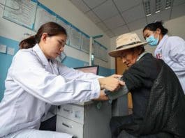 A doctor from Xiangyang, central China's Hubei province, tests blood pressure for a local resident in Qonggyai county of Shannan, southwest China's Xizang autonomous region, Aug. 9, 2024. (Photo by Yang Dong/People's Daily Online)