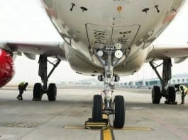 Technicians Carefully Examine The Tires Of An Aircraft