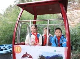 Children from Nizhu River village take a cable car. (Photo by Jia Liyao)