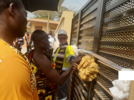Nana Kusi Boadum, Ntotroso Twafohene (middle) being supported to cut a tape to officially open the facility.