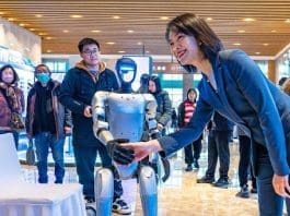 A woman shakes hands with a humanoid robot at the 2024 Global AI Product and Application Expo in Suzhou, east China's Jiangsu province, Dec. 10, 2024. (Photo by Zhang Feng/People's Daily Online)