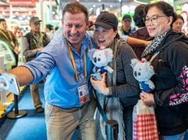 An Australian exhibitor poses for a picture with visitors at the seventh China International Import Expo (CIIE), Nov. 8, 2024. (Photo by Wang Chu/People's Daily Online)