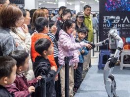 Children shake hands with a robot developed by Unitree Robotics, a pioneer in humanoid robot development, at an AI intelligent robot exhibition held in Suzhou, east China's Jiangsu province, Feb. 28, 2025. (Photo by Wu Xue/People's Daily Online)