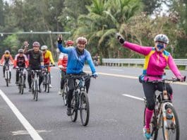 Riders travel along a picturesque tourism highway in Tanmen town, Qionghai, south China's Hainan province. (Photo by Meng Zhongde/People's Daily Online)
