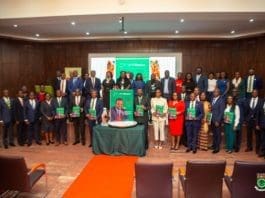 Dignitaries And Participants In A Group Photograph Each Holding A Copy Of The Magazine